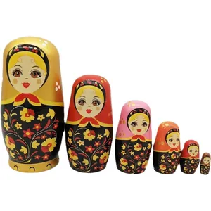 Traditionele zesdelige houten Russische matroesjka-poppen met bloemmotieven en goud