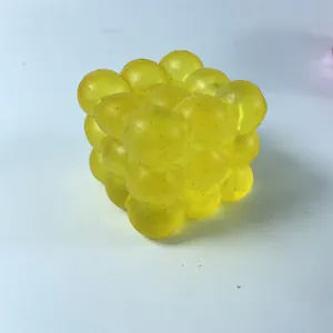 Détail d'un jouet anti-stress cube à bulles jaune à rebond lent pour presser