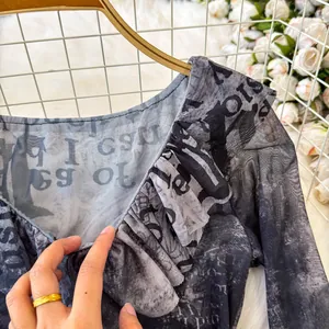 Dettaglio della maglietta vintage in mesh tie-dye con un elegante scollo a V a balze