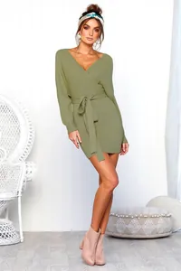 Full length view of a sage green long-sleeved V-neck wrap dress with waist tie details.