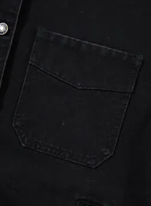 Detailansicht der Taschennähte einer schwarzen Oversize-Jeansjacke für Damen-Outfits
