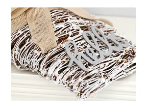 Détail d'une couronne de cœur tressée blanche avec nœud en toile de jute et Hello