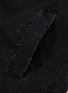 Makroaufnahme der Tasche und Nähte an einer schwarzen Oversize-Jeansjacke für Damen