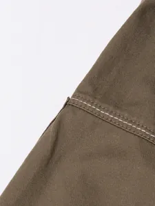 Close-up of white contrast stitching on heavy brown twill fabric skirt detail