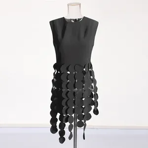 Detail view of black sleeveless top featuring unique circular fabric piece fringe design