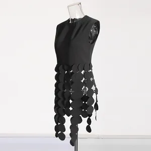 Side profile of black sleeveless top showcasing intricate hanging round disc fringe details