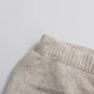 Macro detail view of a soft oatmeal knitted waistband featuring premium ribbed texture.