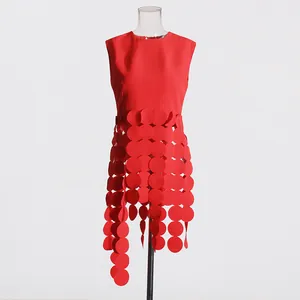 Detail view of a vibrant red sleeveless top with a unique circular fringe design