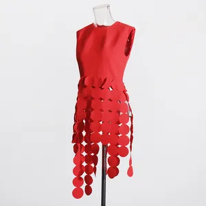 Macro detail showing the unique red circular fringe design on a sleeveless top.