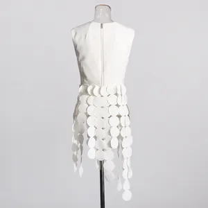 Detailed view of the back zipper and unique circular disc fringe on a white sleeveless top.