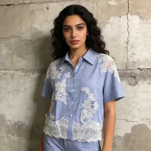Dettaglio di camicia a maniche corte a righe bianche e blu con ricami in pizzo bianco