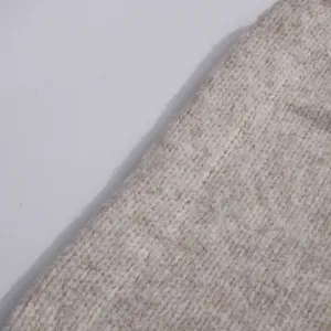 Macro view of oatmeal beige knitted fabric texture showing soft high-quality wool yarn