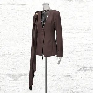 Detailed view of a brown slim-fit blazer with an elegant asymmetrical sash drape.