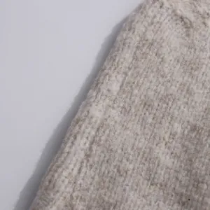 Detailed macro view of the oatmeal melange knit fabric texture with ribbed pattern detail.