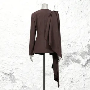 Detailed back view of a brown blazer with a unique draped fabric accent on shoulder.