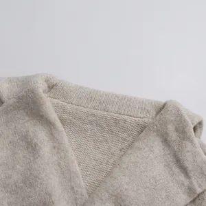 High-quality close-up detail of the oatmeal knit sweater collar showing soft fabric texture