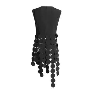 Detail view of a black sleeveless top with unique circular fringe and tassel design.