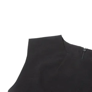 Macro view of shoulder seam and back zipper detail on a minimalist black sleeveless top.
