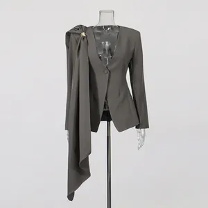 Detail view of a grey slim-fit blazer with unique asymmetrical draped scarf decor.