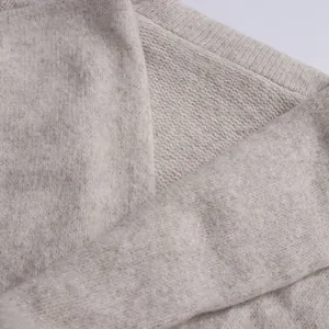 Macro detail of soft oatmeal knitted fabric showing thick yarn texture and weave
