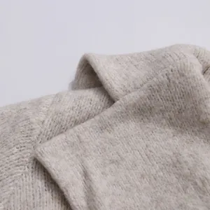 Close-up detail of soft beige rib-knit fabric showing high-quality wool texture