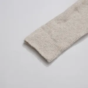 Close-up detail of soft oatmeal knitted sweater cuff showing texture