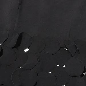 Detail of black sleeveless top featuring layered circular fabric petal hem design