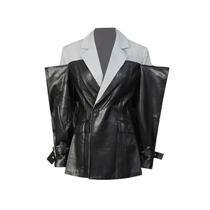 Detail van een grijze en zwarte leren patchwork blazer met unieke gespen aan de mouwen