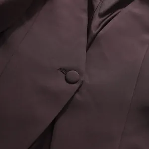 Macro view of high-quality fabric and matching cloth-covered button on a designer blazer jacket