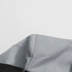 Detailopname van grijze stof en zwart lederen patchwork op een minimalistische blazer