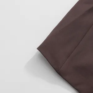 Close-up detail showing the fine stitching and smooth fabric texture of the brown blazer.
