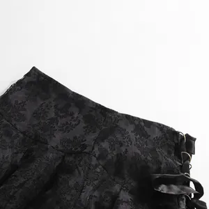 Dettaglio ravvicinato della gonna in pizzo jacquard nero con lacci e anelli laterali