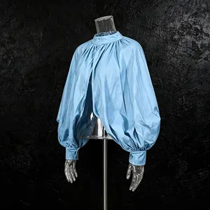 Detailweergave van een lichtblauwe vintage blouse met opstaande kraag en pofmouwen.
