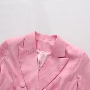 Vue détaillée d'un blazer rose à double boutonnage avec finition texturée et revers cranté
