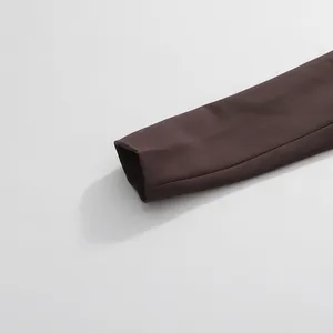 Close-up macro detail of a dark brown women's blazer sleeve cuff showing clean stitching.