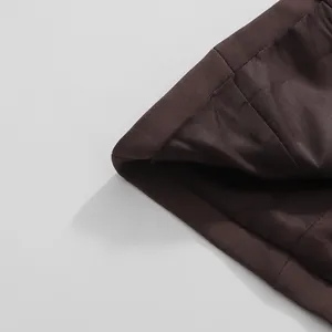 Detailed macro shot of the high-quality inner lining and hem of a dark brown women's blazer