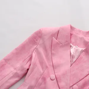 Vue détaillée d'un blazer croisé rose avec col en V et texture de tissu marbrée élégante
