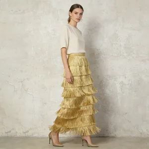 Detailed side view of a shimmering gold tiered fringe maxi skirt with layered tassels
