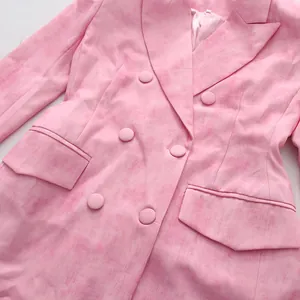 Gros plan d'un blazer croisé rose avec tissu texturé et détails de revers chic