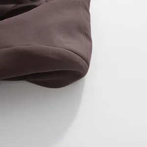 Macro view showing the fine fabric texture and stitching of the brown suit jacket