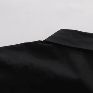 Dettaglio ravvicinato del tessuto nero e del colletto di una camicia a maniche corte