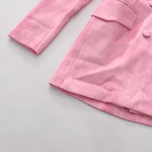 Gros plan d'un blazer rose croisé montrant la poche et la texture du tissu