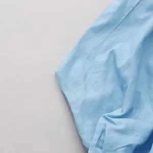 Detail van lichtblauwe stoftextuur van een retro pofmouwen shirt voor een streetstyle look.