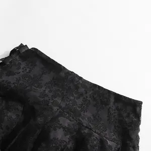 Vista dettagliata del tessuto jacquard in pizzo nero con elegante motivo a lacci e fiocco