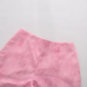 Gros plan sur la taille et les coutures du short rose texturé au style minimaliste