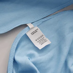 Close-up van het waslabel op een lichtblauw overhemd van een polyester en spandex mengsel