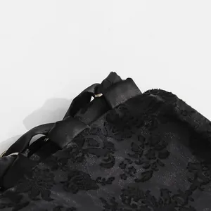 Dettaglio macro della gonna in pizzo jacquard nero con chiusura a fiocco e anello