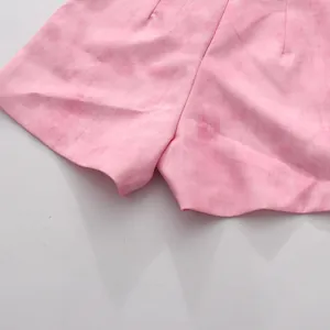 Gros plan d'un short décontracté rose avec tissu texturé et détail de l'ourlet