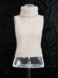 Beige sleeveless turtleneck knit sweater on mannequin against textured dark stone background