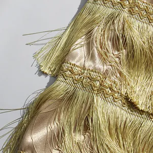 Macro view of luxurious gold layered tassels on a high-waist satin skirt